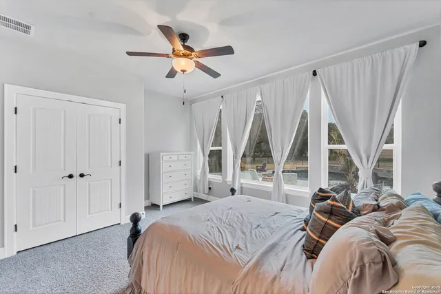 a bedroom with a bed and a large window