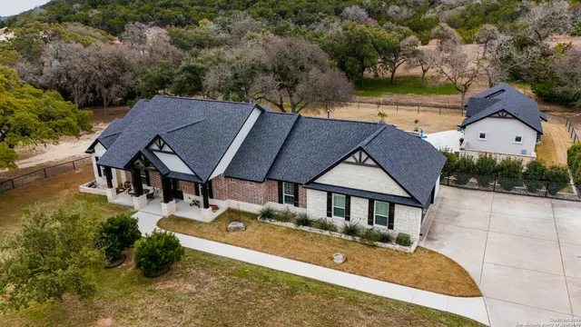 an aerial view of a house with swimming pool and garden