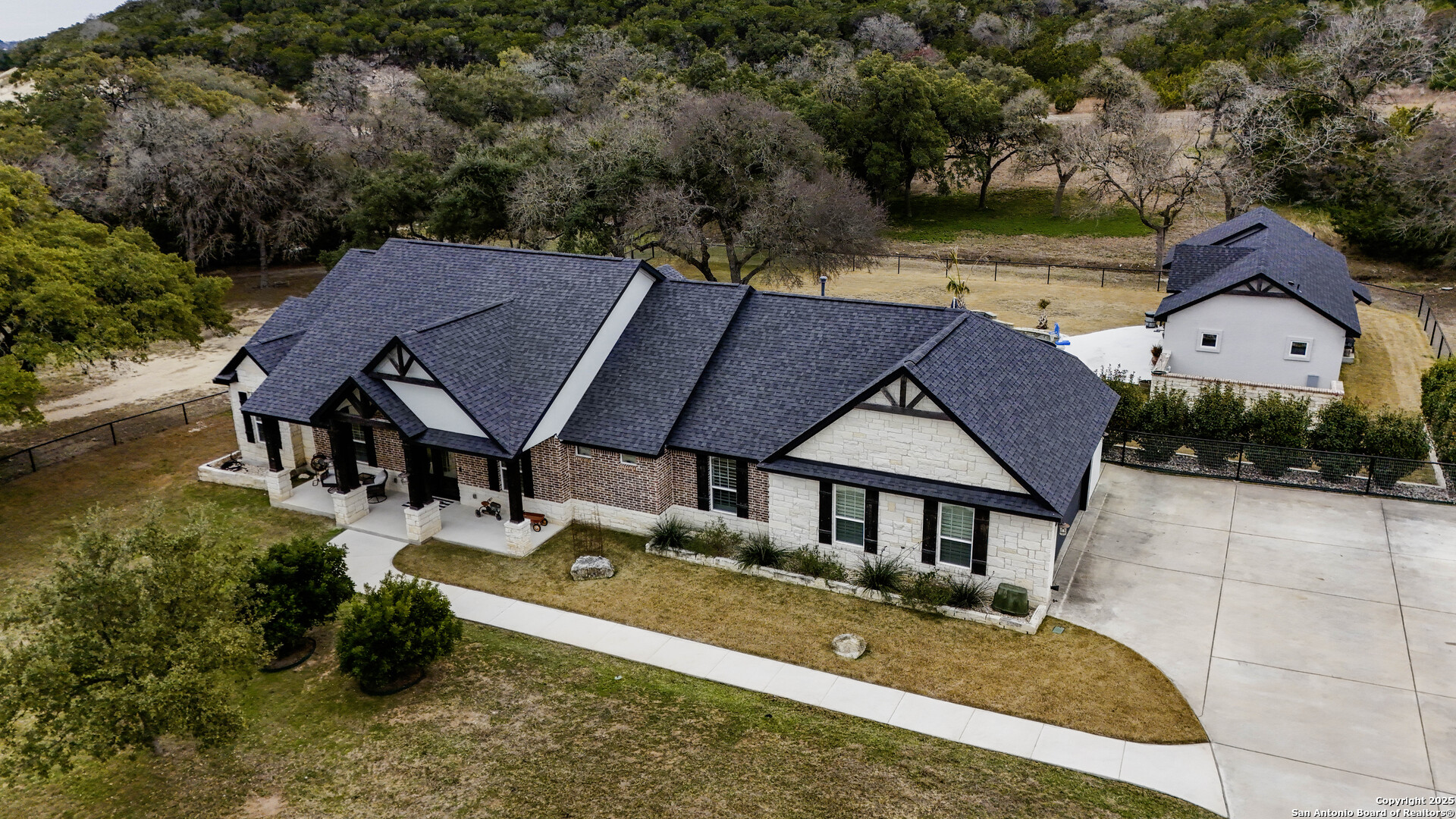 1033 Mystic Shores Boulevard Spring Branch, TX 78070 - Photo 2 of 39 an aerial view of a house with swimming pool and garden