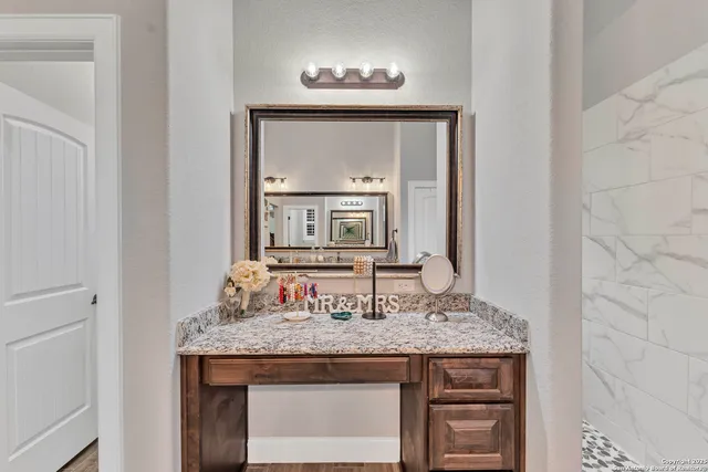 a bathroom with a granite countertop sink and a mirror