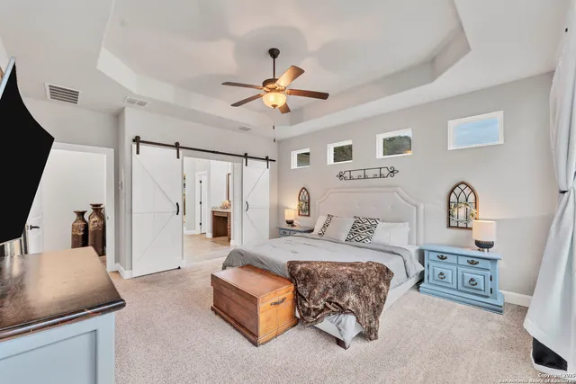 a bedroom with a bed couch and a flat tv screen