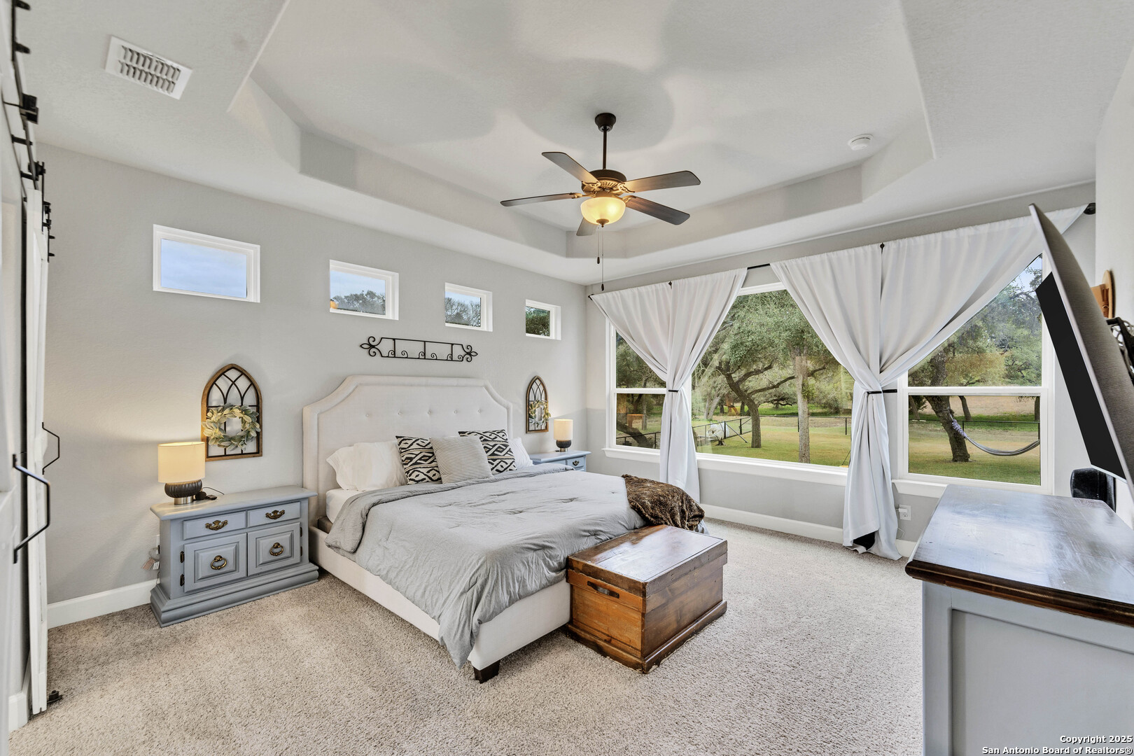 1033 Mystic Shores Boulevard Spring Branch, TX 78070 - Photo 27 of 39 a bedroom with a bed a chandelier and a large window