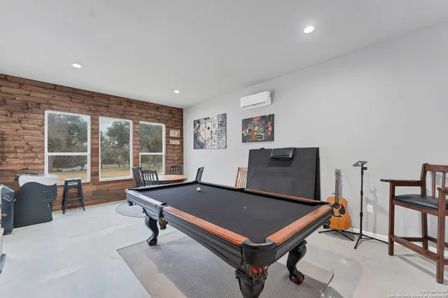 a living room with furniture pool table and a large window