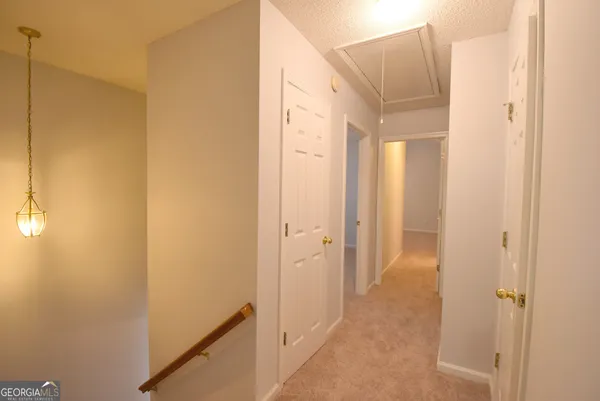 a view of a hallway with wooden shelves