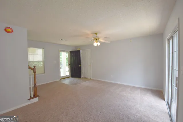 an empty room with windows and mirror