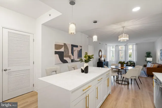 a kitchen with kitchen island a refrigerator a stove a sink a dining table and chairs