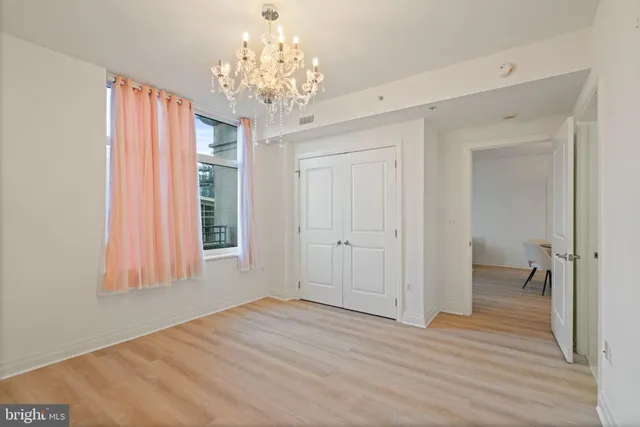 wooden floor in an empty room with a chandelier