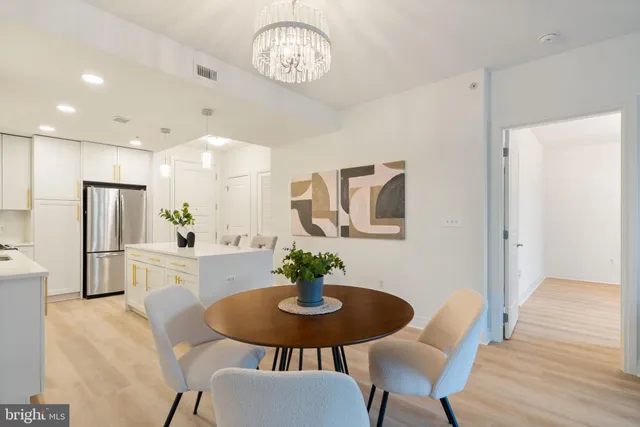 a living room with furniture and a dining table with wooden floor