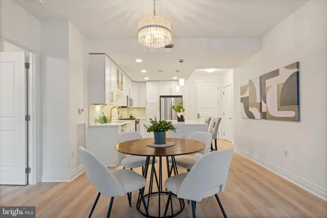 a view of a dining room with furniture a chandelier and wooden floor