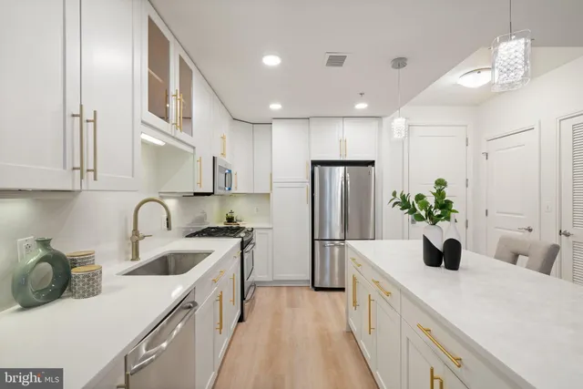 a kitchen with a stove a sink and a refrigerator