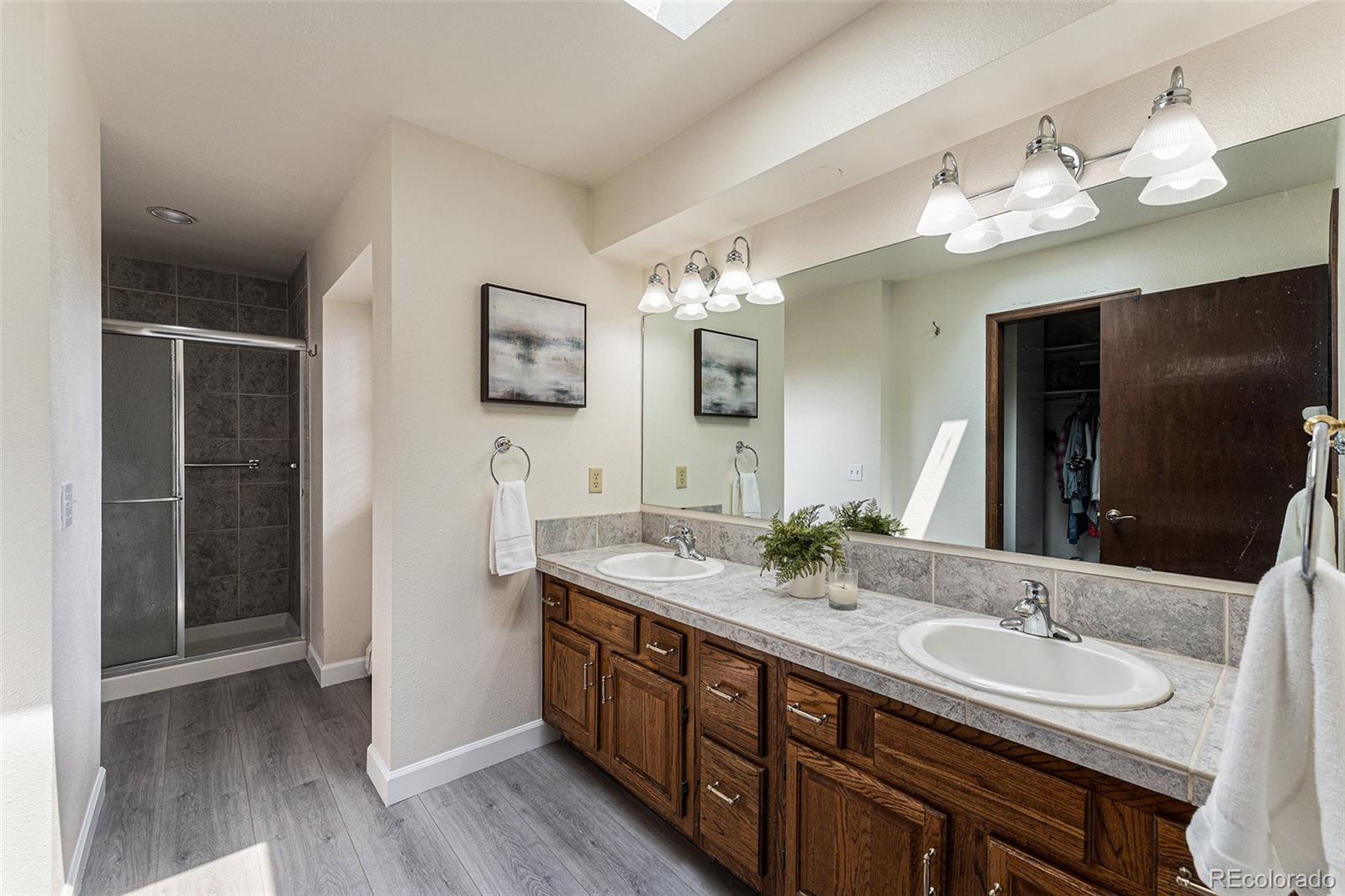 217 South Deframe Way Golden, CO 80401 - Photo 21 of 34 a bathroom with double vanity sink a vanity and a large mirror