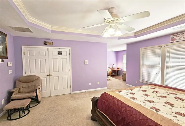 a spacious bedroom with a bed a dresser and a window
