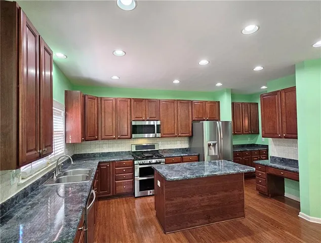 a kitchen with granite countertop wooden cabinets a stove and a stainless steel appliances