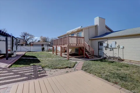 a view of a patio with table and chairs with wooden floor and fence
