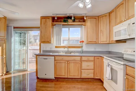 a kitchen with stainless steel appliances granite countertop a sink and cabinets with wooden floor