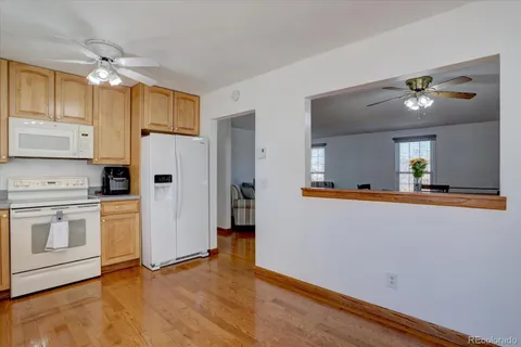 a view of a kitchen with a refrigerator a microwave and a sink