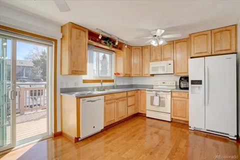 a kitchen with granite countertop white cabinets and white appliances