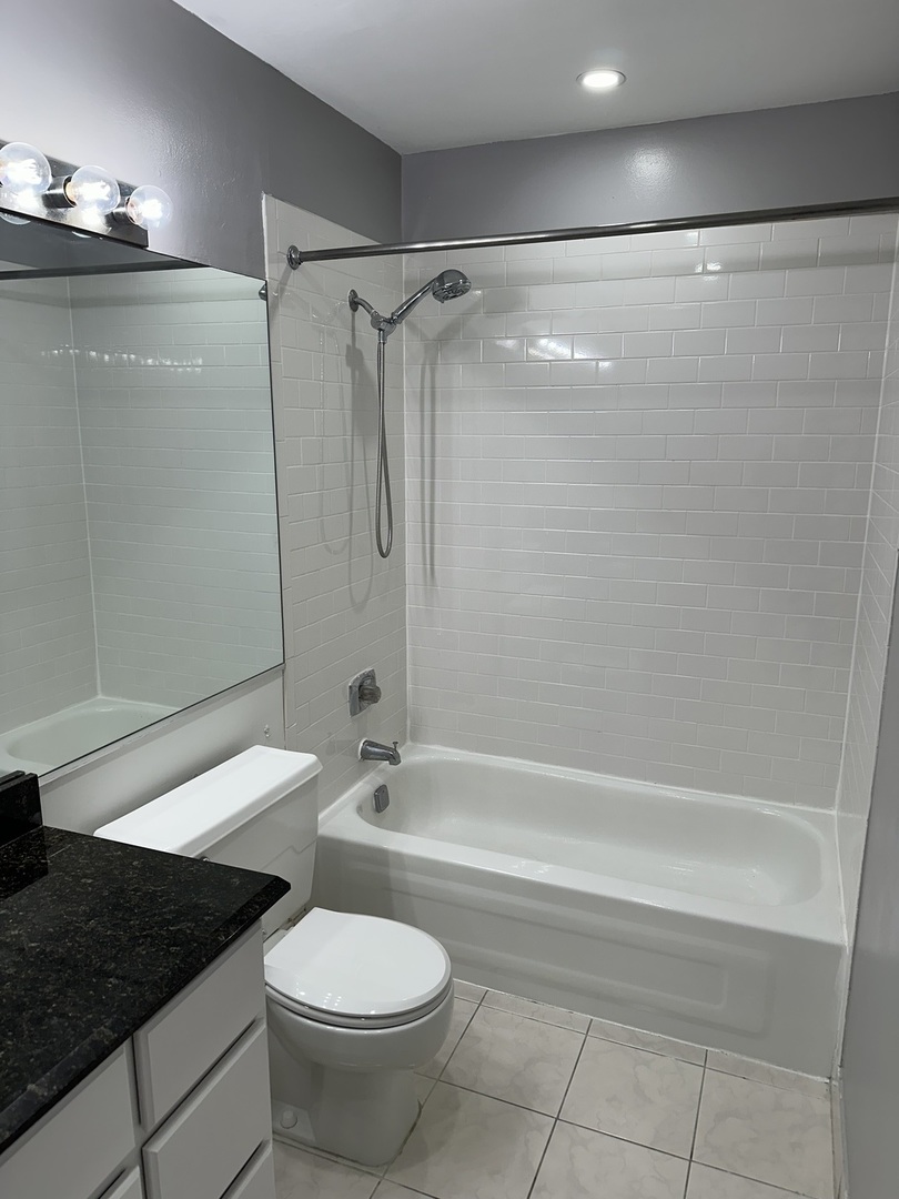 431 South Dearborn Street, Unit 507 Chicago, IL 60605 - Photo 15 of 25 a bathroom with a granite countertop bathtub shower sink and toilet