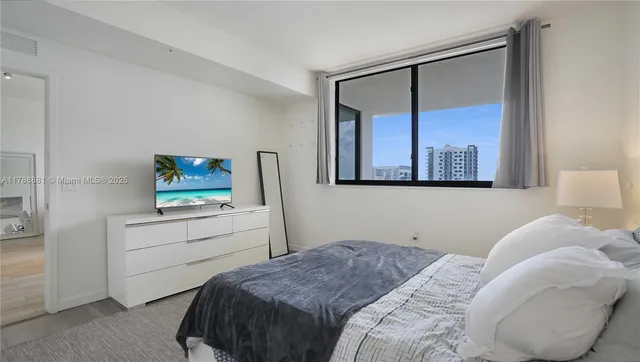 a bedroom with a bed and a mirror on the dresser