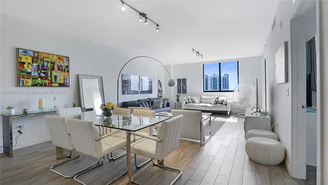 a living room with furniture a wooden floor and a large window