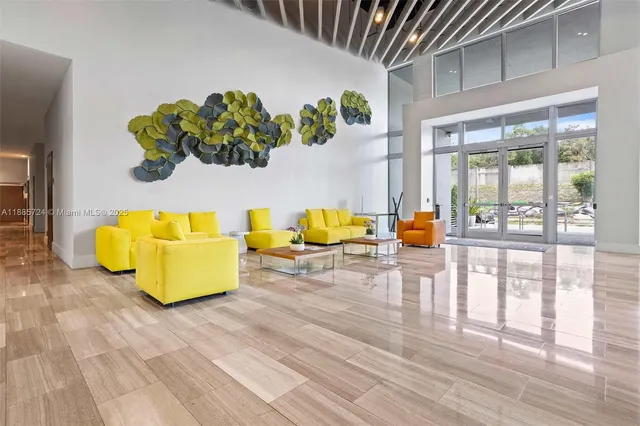 a living room with couches painting on the wall and a potted plant