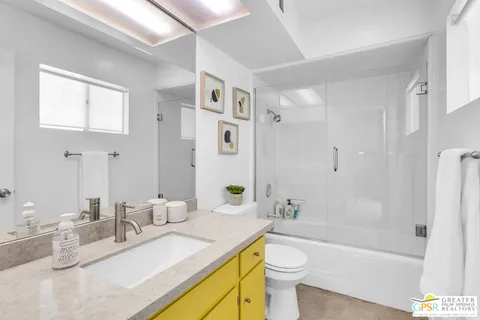 a bathroom with a granite countertop sink mirror toilet and bathtub