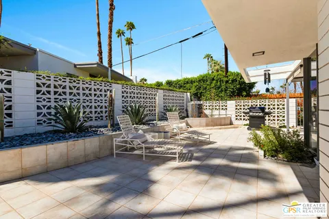 a view of a patio with table and chairs potted plants