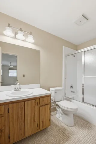 a bathroom with a double vanity sink toilet and shower