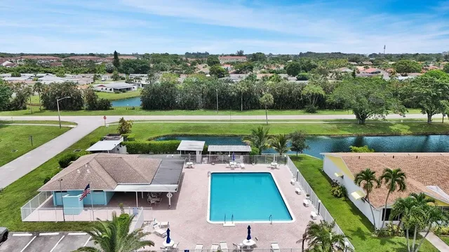 an aerial view of a house with a swimming pool a patio and yard