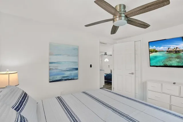 a view of a bedroom with wooden floor and windows