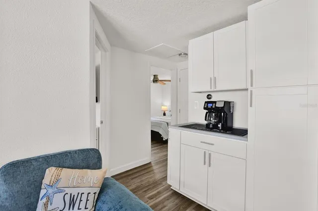 a kitchen with white cabinets and sink