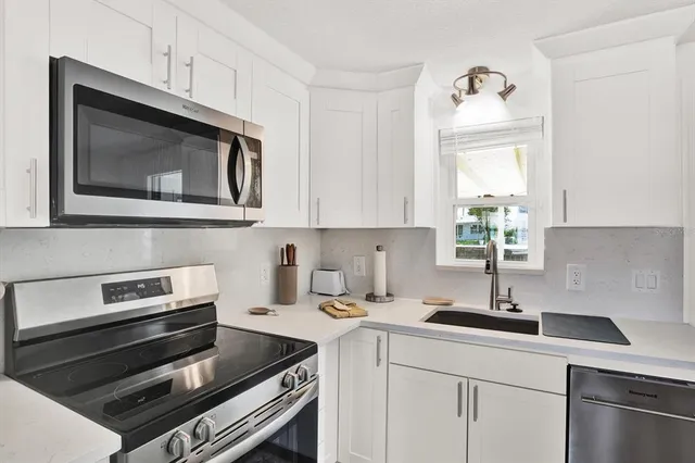 a kitchen with a sink stove and microwave