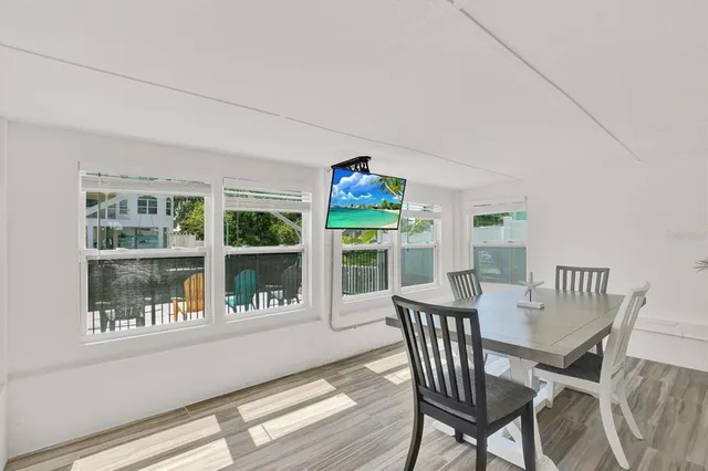 a view of a dining room with furniture large windows and garden view