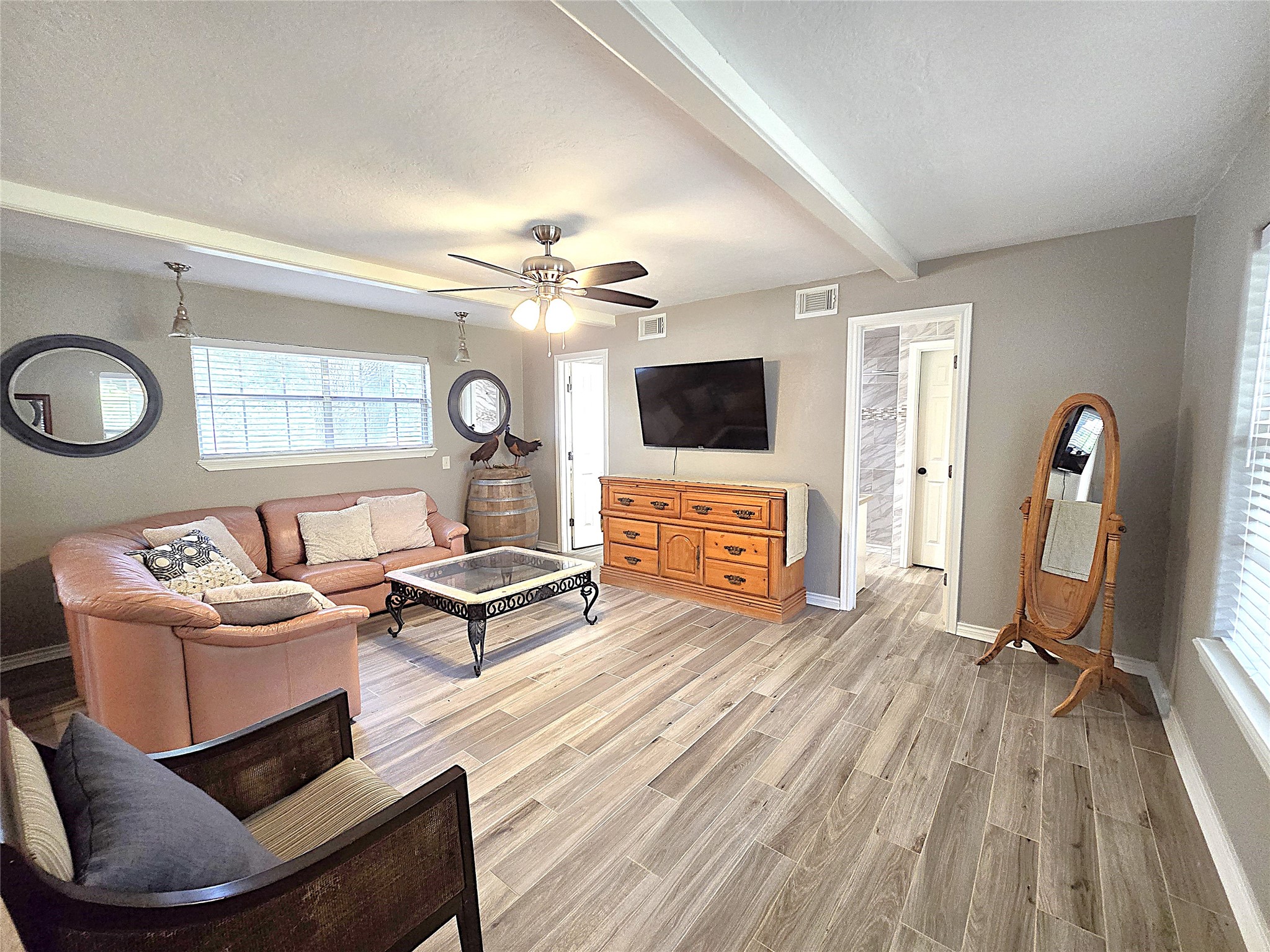 560 Brandon Road Conroe, TX 77302 - Photo 29 of 45 Spacious and inviting living room with stylish decor, featuring a cozy seating area, modern ceiling fan, and abundant natural light. Ideal for relaxation and entertaining.