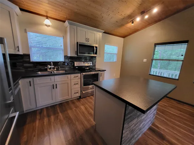 a kitchen with stainless steel appliances a stove sink microwave and cabinets