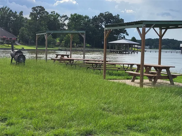 a view of a swimming pool with a bench and lawn chairs