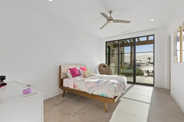 a spacious en suite bathroom with a double vanity sink a mirror and a toilet