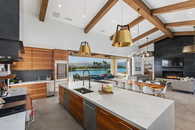 a large kitchen with stainless steel appliances granite countertop a sink and a counter top space
