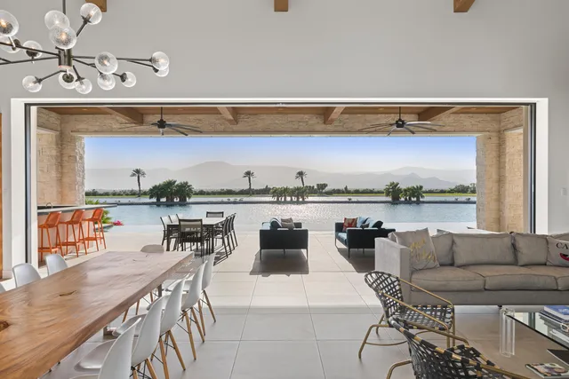 a living room with furniture a rug and kitchen view