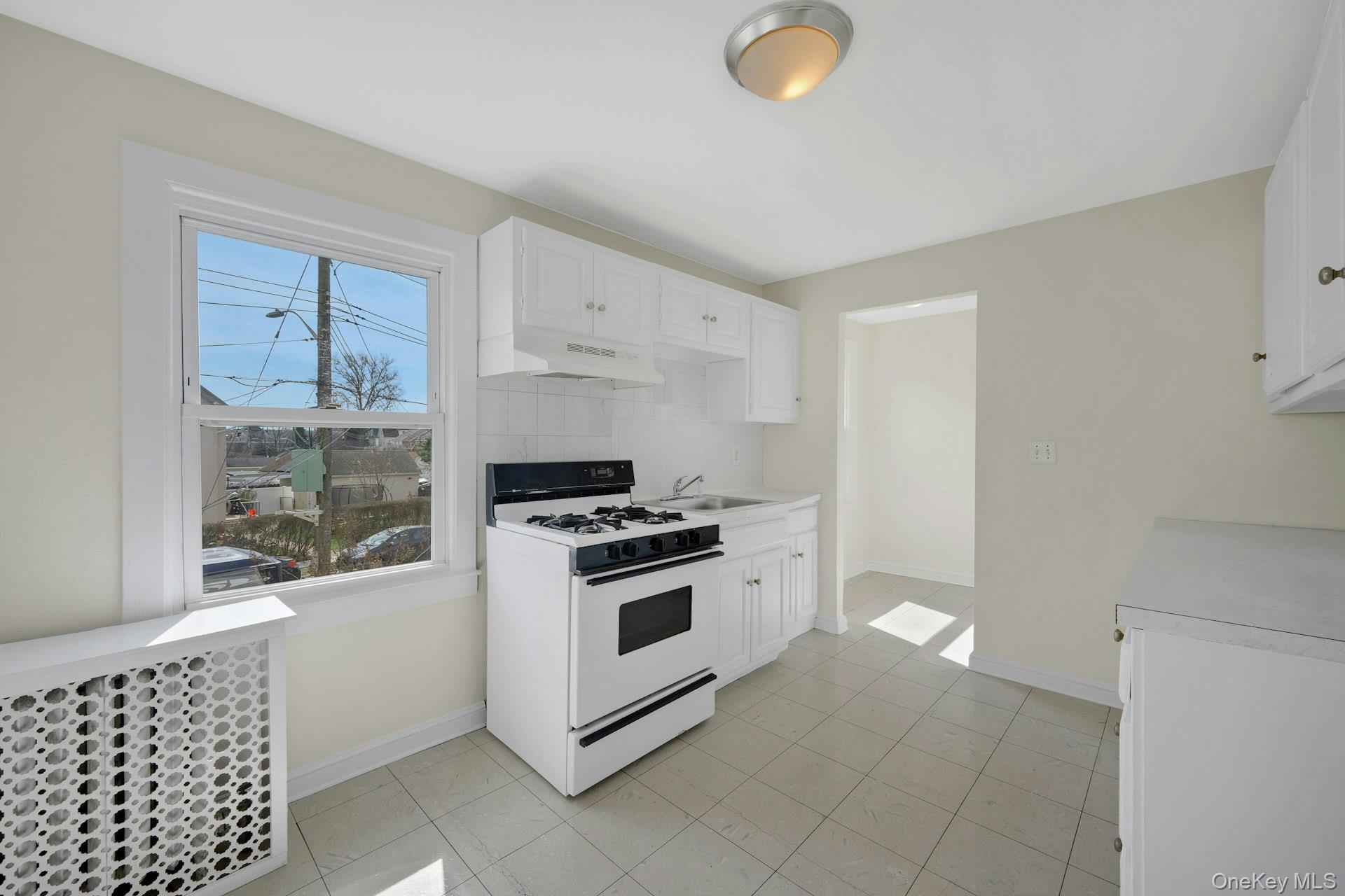56 Stephenson Boulevard New Rochelle, NY 10801 - Photo 15 of 44 a kitchen with a stove a sink and a window