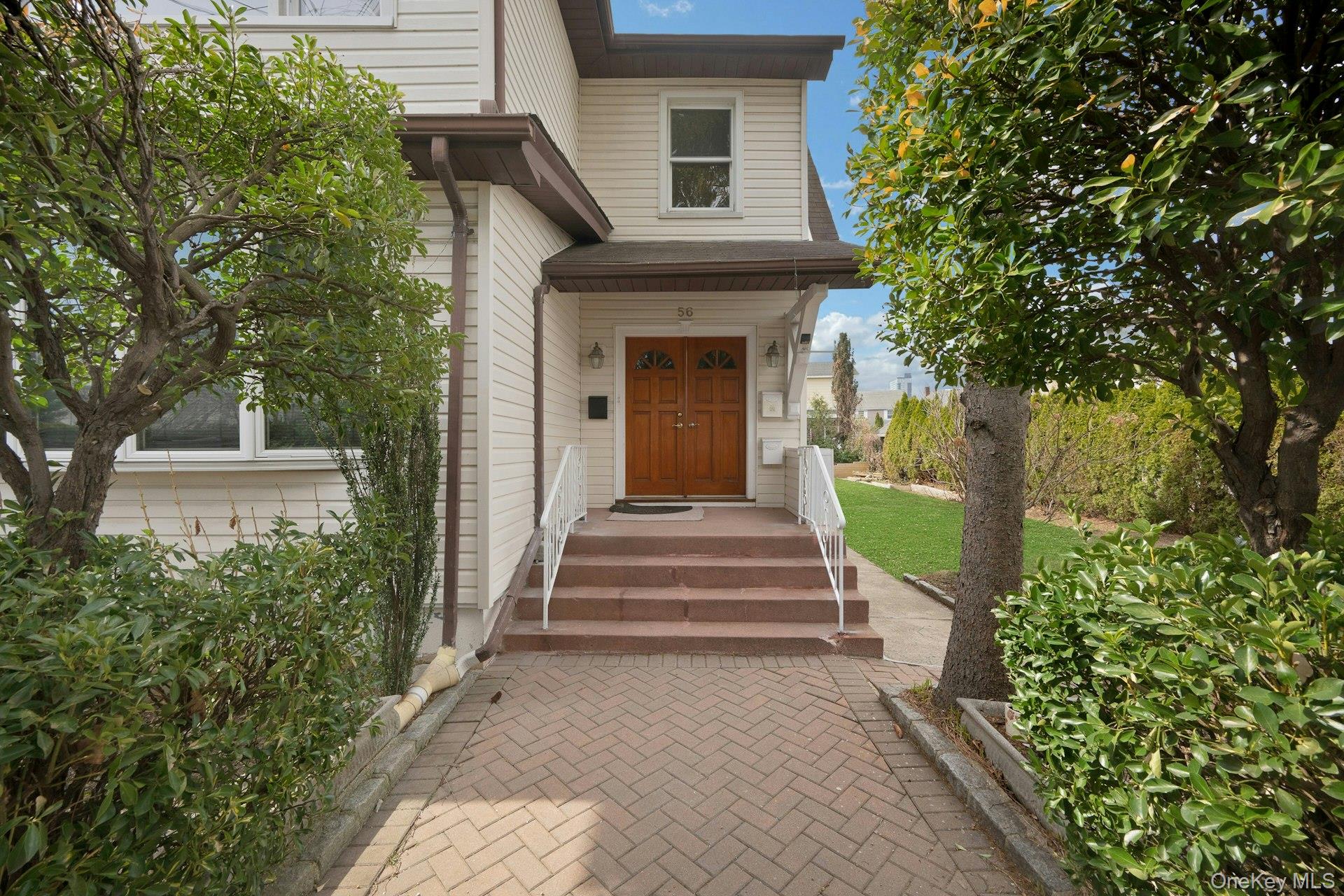 56 Stephenson Boulevard New Rochelle, NY 10801 - Photo 3 of 44 a view of a house with large windows and a small yard