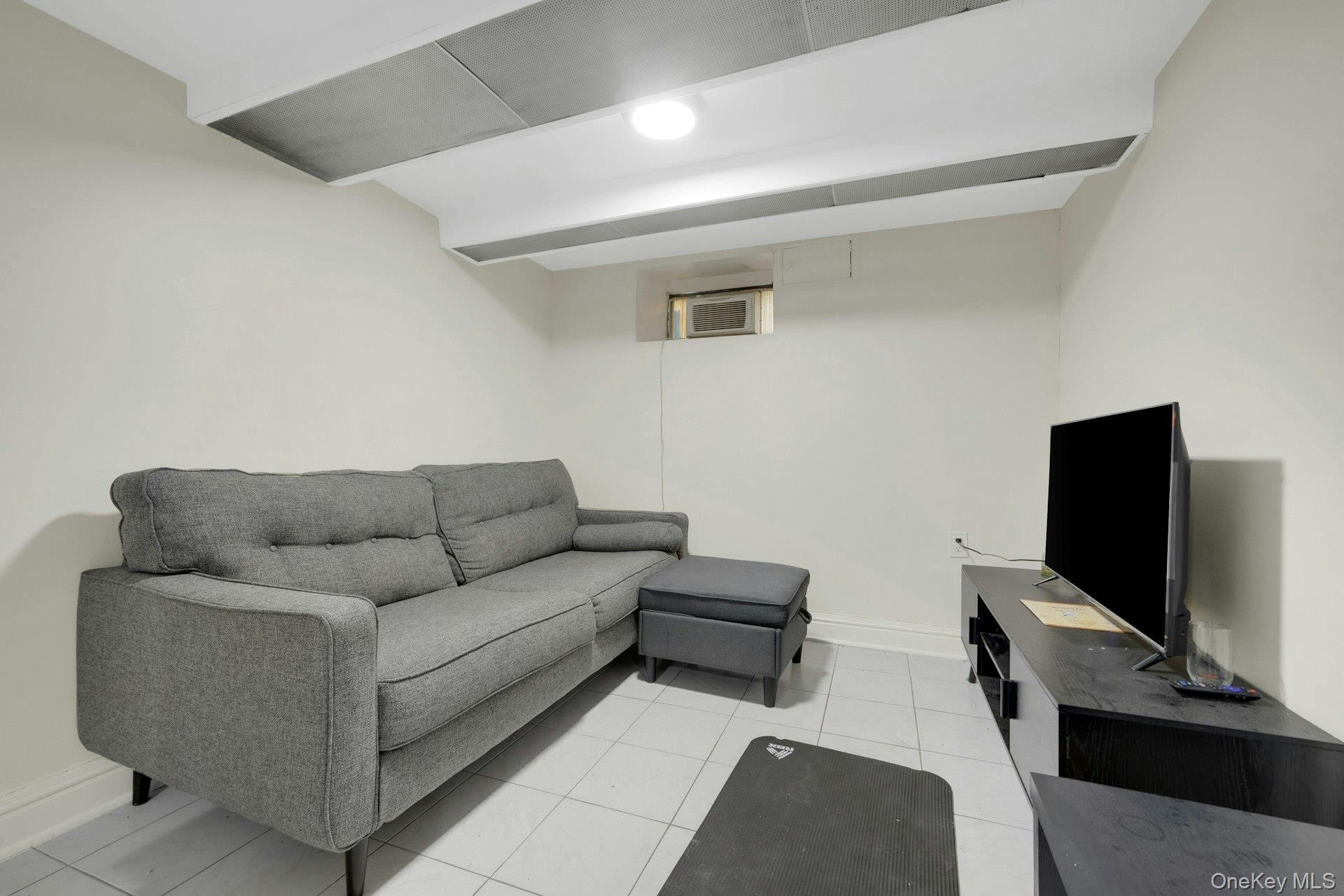 56 Stephenson Boulevard New Rochelle, NY 10801 - Photo 32 of 44 a living room with furniture and a flat screen tv