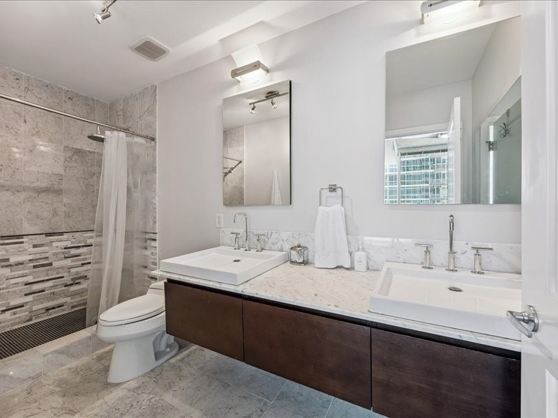 5925 Almeda Road, Unit 10714 Houston, TX 77004 - Photo 14 of 38 a bathroom with a double vanity sink toilet and shower