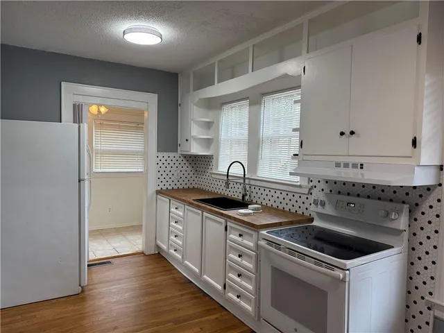 a kitchen with granite countertop a sink stove and cabinets