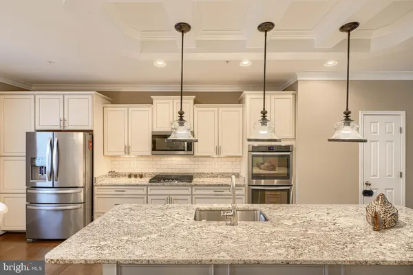 a kitchen with kitchen island a stove a refrigerator and cabinets