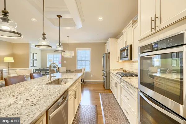 a large kitchen with stainless steel appliances granite countertop a lot of counter space