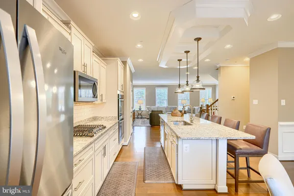 a large kitchen with a counter space a sink stainless steel appliances and cabinets