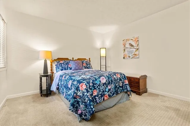 a bedroom with a bed and painting on the wall