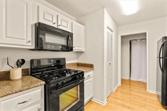 a kitchen with stainless steel appliances granite countertop a stove and a microwave