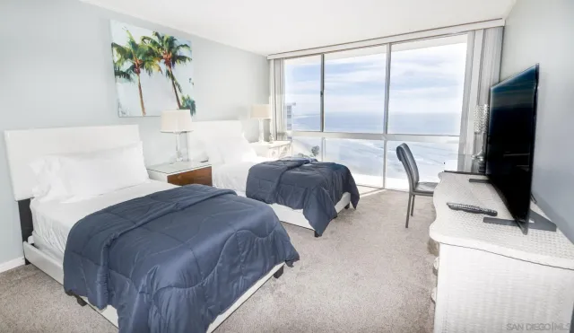 a bedroom with two beds and a potted plant